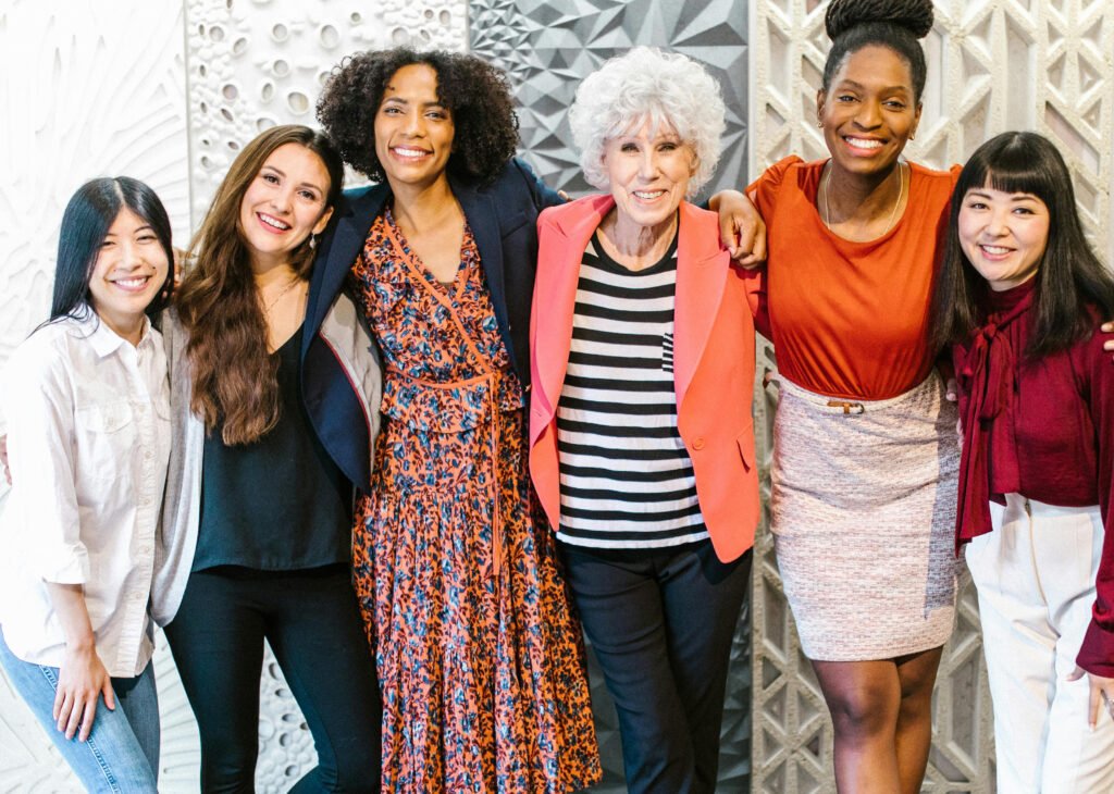 six smiling women of varying ethnicities
